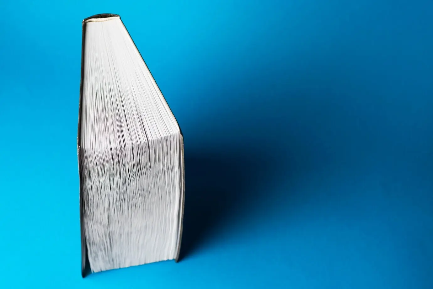 Blauer Hintergrund mit einem aufrecht stehenden Buch