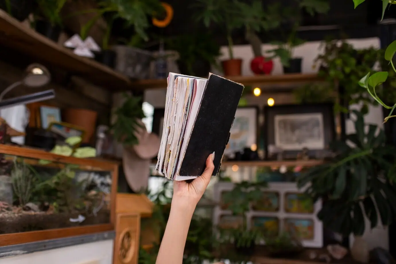 Nahaufnahme einer Hand, die ein Tagebuch hält.